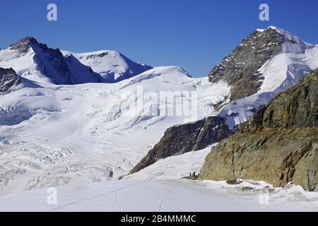 Blick vom Moenchsjoch über den Jungfraufirn nach links Dreieckhorn und Gletscherhorn. Im Vordergrund Bergsteiger am Eingang zum Südostkamm der Moench. Stockfoto