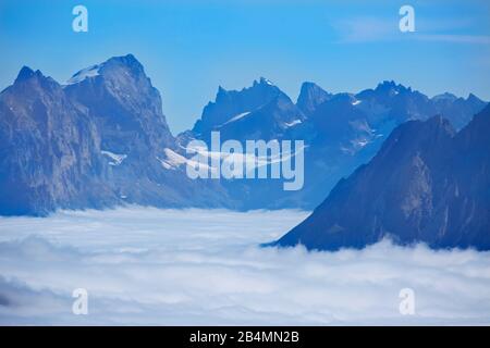 Blick von Maennlichen bei Wengen über das unter einer Nebeldecke liegende Haslital in die Berner Alpen mit dem Titlis und dem Fuenffingerstock. Stockfoto