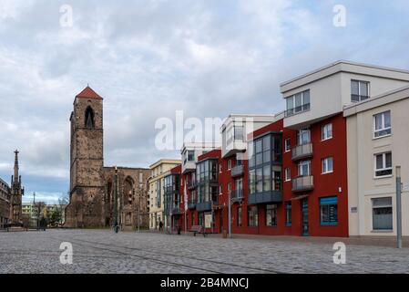 Deutschland, Sachsen-Anhalt, Zerbst, Blick auf moderne Wohnbauten mit den Touristeninformationen von Zerbst. Im Hintergrund sind die Ruinen der Stadtkirche St. Nikolai zu sehen. Sie wurden in den letzten Kriegstagen 1945 zerstört. Stockfoto