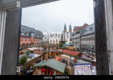 Deutschland, Niedersachsen, Harz, Goslar, Blick aus einem Fenster auf den traditionellen Weihnachtsmarkt in Goslar. Stockfoto