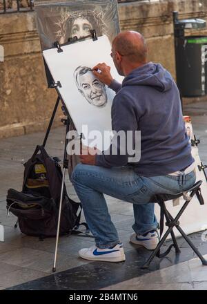 Eines Tages in Málaga; Impressionen aus dieser Stadt in Andalusien, Spanien. Straßenkünstler zeichnet ein Porträt mit Holzkohle. Stockfoto