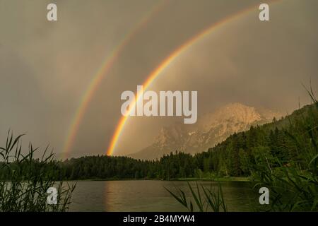 Ein gigantischer Doppelregenbogen vor dem Karwendel über dem Lautersee Stockfoto