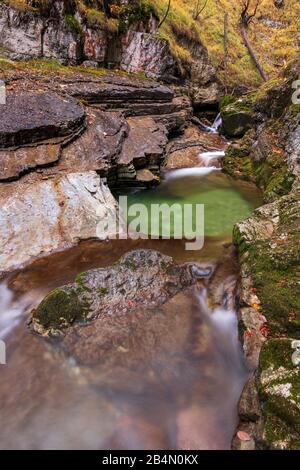 Ein Becken im Gerbigsbach des Kuhfluchtfalls bei Garmisch-Partenkirchen in den bayerischen Alpen mit klarem, sauberem Wasser. Stockfoto