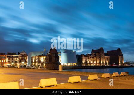 Deutschland, Mecklenburg-Vorpommern, Stralsund, Ozeaneum, Hotels, Restaurants und Geschäfte am Hafen, blaue Stunde Stockfoto