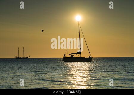 Ostsee im strahlenden Rücklicht und am Horizont Segelschiffe in untergehenden Sonne. Stockfoto