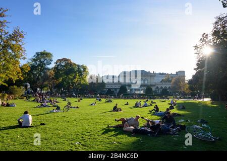 Wien, Park Stadtpark, Wiese, Menschen sonnen, reden, Haus Kursalon Hübner in Österreich, Wien, 01. Bezirk, Altstadt Stockfoto