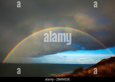 Regenbogen vor Sturmwolke am Omaha Beach in der Normandie Stockfoto