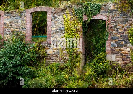 Trockene Steinmauer am Fluss mit Tür- und Fensterhöhlen. Pontrieux ist eine Gemeinde in der Region Bretagne im Département Côtes-d'Armor im Kanton Bégard. Er liegt am Ufer des Flusses Trieux Stockfoto