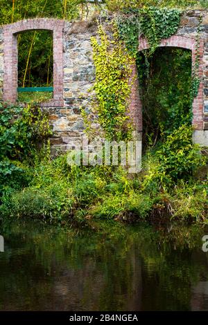 Trockene Steinmauer am Fluss mit Tür- und Fensterhöhlen. Pontrieux ist eine Gemeinde in der Region Bretagne im Département Côtes-d'Armor im Kanton Bégard. Er liegt am Ufer des Flusses Trieux Stockfoto