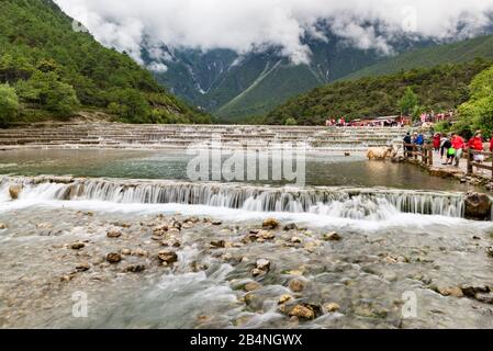 Lange Aufnahme eines von mehreren smaragdfarbenen Wasserfällen im Blue Moon Valley am Fuß des Jade Dragon Snow Mnt (Yulong Xue Shan) in Lijiang, Yunnan Stockfoto