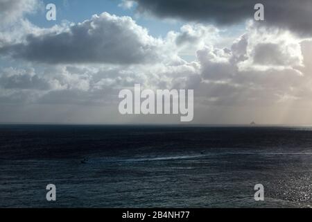 Regenschauer über der Bucht von Mont-Saint-Michel an der Côte d'Émeraude. Zwei Motorboote im Vordergrund und im Hintergrund der Mont-Saint-Michel. Stockfoto