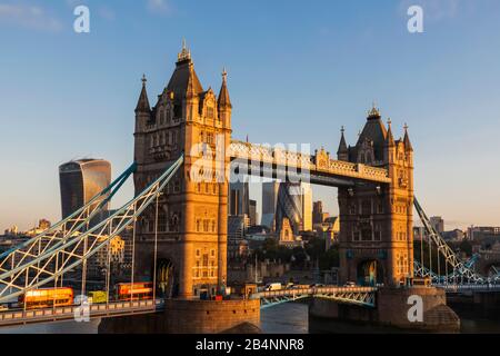 England, London, Tower Bridge, rote Doppeldeckerbusse Crossing Tower Bridge im Morgenlicht Stockfoto