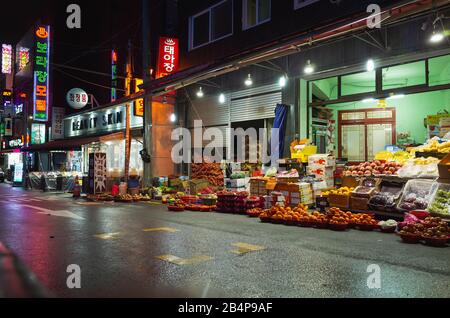 Busan, Südkorea - 23. März 2018: Nächtlicher Blick auf die Straße der asiatischen Stadt mit Nachtmarkt, Obst und Gemüse zum Verkauf Stockfoto