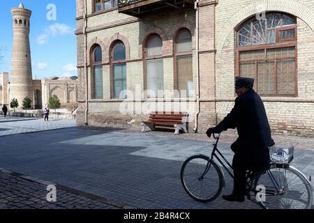 Mann, der auf der Straße in Buchara, Usbekistan radelt Stockfoto