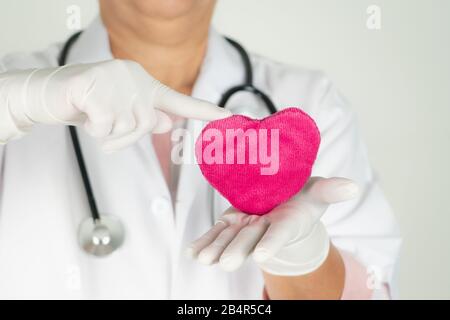 World Heart Health Day Concept und Healthcare Medical Insurance mit Arzt mit Stethoskop, das rotes Herz hält Stockfoto