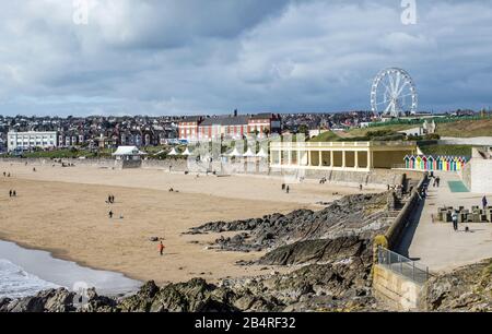 Blick auf die Whitmore Bay auf Barry Island an einem Märzmorgen, der den Strand, die Menschen, das Big Wheel und mehr zeigt, in Südwales an der Küste. Stockfoto