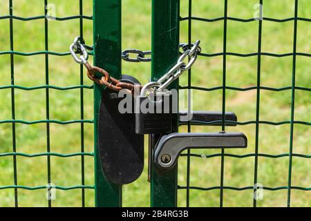 Zaun mit Eisenkette und schwerem Vorhängeschloss geschlossen Stockfoto