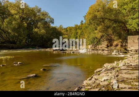 Altes zerbrochenes Wehr an einem Fluss unter Bäumen im Sommer, Stribro Stockfoto