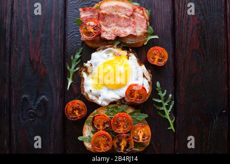 Sandwiches mit Ei und Speck Tomaten und Arugula Stockfoto