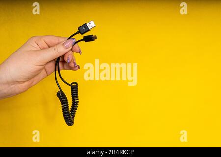 USB-Kabel in Hand-Nahaufnahme. Aufladen des Telefons Stockfoto