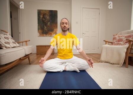 Ein Mann, der als Teil seiner Yoga-Routine meditiert Stockfoto