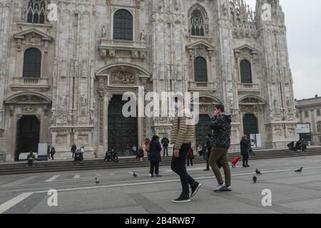 Menschen und Touristen, die am 25. Februar 2020 eine Schutzmaske tragen, spazieren auf der Piazza Duomo in Mailand, Italien Stockfoto