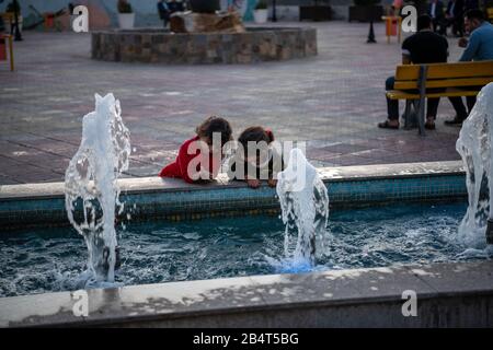 Irak, Iraq Kurdistan, Arbil, Erbil. Vor einem Parkbrunnen stehen zwei Kinder playinf. Stockfoto