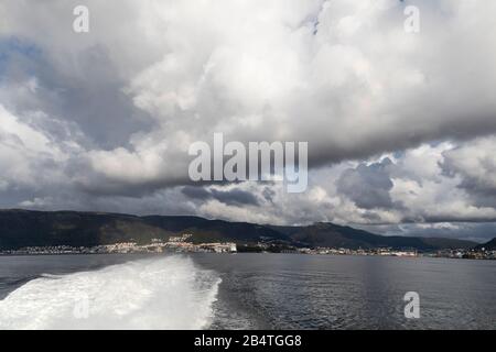 Schwere Wolken über Byfjorden und der Stadt Bergen, Norwegen. Ansicht von einem Passagierschiff mit hoher Geschwindigkeit. Stockfoto