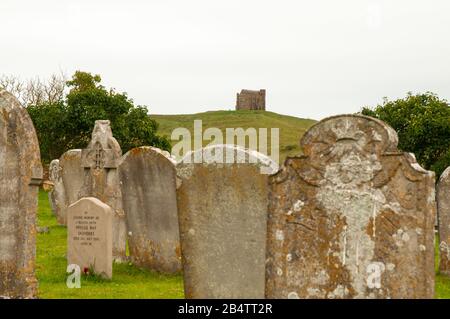 Blick auf die St Catherine's Chapel auf einem Hügel in Abbotsbury, vom Friedhof der St. Nicholas Kirche mit Grabsteinen, Dorset, England. Stockfoto