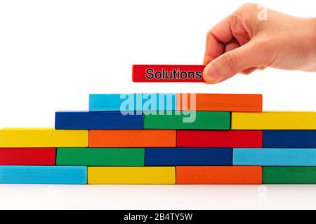 Füllen Sie das Konzept der Business-Lösungen aus, ein Holzblock-Puzzle, das auf Holzstapel aufgesetzt wird Stockfoto