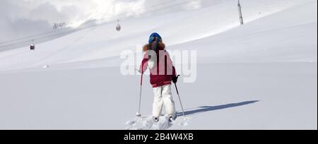 Mädchen auf Skiern in schneebedecktem Gelände mit neuem Schnee an einem schönen Wintertag. Kaukasusgebirge, Georgien, Region Gudauri. Panoramaaussicht. Stockfoto