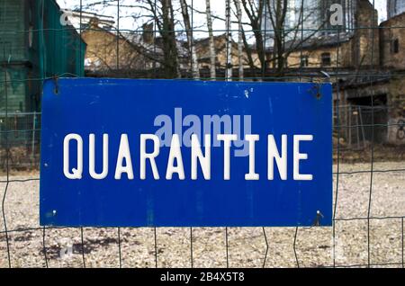 Blaues Warnschild an einem Zaun - Quarantäne. Warnung vor epidemischer Quarantäne. Coronavirus-Krankheit. NCoV-Warnzeichen. Biohazard, nicht Transpassing. Stockfoto