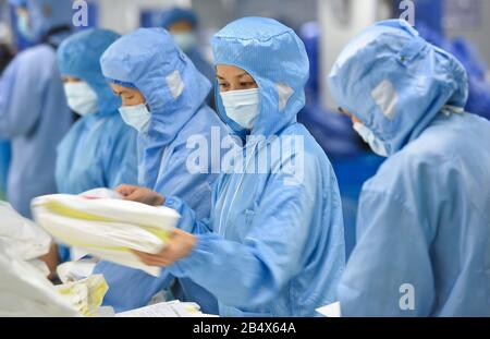 Peking, Chinas Provinz Guangdong. März 2020. Arbeiter packen Schutzanzüge in der Werkstatt von Foshan Nanhai Plus Medical Co., Ltd. In Foshan, Südchinas Provinz Guangdong, 3. März 2020. Kredit: Liu Dawei/Xinhua/Alamy Live News Stockfoto