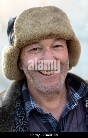 Porträt eines freundlichen usbekischen Verkäufers mit Pelzhut und goldenen Zähnen, Buchara, Usbekistan Stockfoto