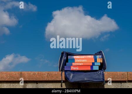 Gruppe gedruckter Touristenführer in einer Tasche gegen den blauen Himmel mit einigen Wolken Stockfoto