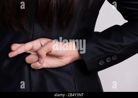 Schließen Sie Geschäftsfrau mit den Fingern hinter ihrem Rücken - Konzept für viel Glück oder Unehrlichkeit Geschäft. Stockfoto