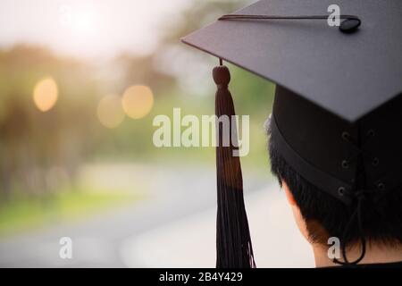 Graduierung. Rückansicht des Studenten mit Hochschulabsolventen überfüllt oder Abschlusskappe bei der Abschlussfeier. Stockfoto