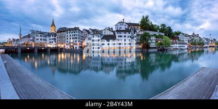 Panorama der Züricher Altstadt mit berühmten Fraumunster, St.-Peter-Kirchen und Limmat in der morgendlichen Blaustunde, Schweiz Stockfoto