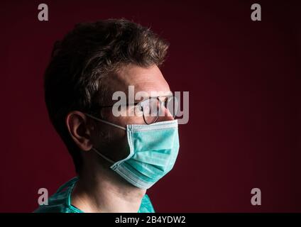 Arzt in ärztlicher Schutzmaske. Krankenschwester in der Brille bereitet sich auf die Operation vor. Medizinische Einwegkleidung von Medic gegen eine Pandemie- und Grippesaison. Stockfoto