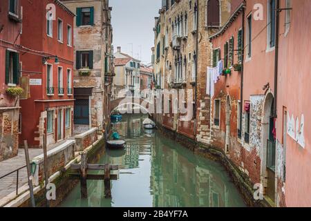 Ein venezianischer Kanal mit Häusern und Wohnungen im Wohnviertel von Venedig, Italien an einem bewölkten Wintertag im Dezember gesäumt Stockfoto