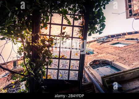 Abstrakte Aufnahme von unten eine verzierte Glasfliesen und eine eiserne Fußgängerbrücke in einer Hintergasse von Venedig, Italien Stockfoto