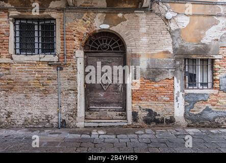 Alte verlassene Holztür und Fenster verwitterten mit zunehmendem Alter. Stockfoto