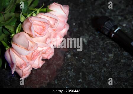 Hintergrund mit violetten, rosafarbenen Rosen auf schwarzem Marmorhintergrund. Stockfoto