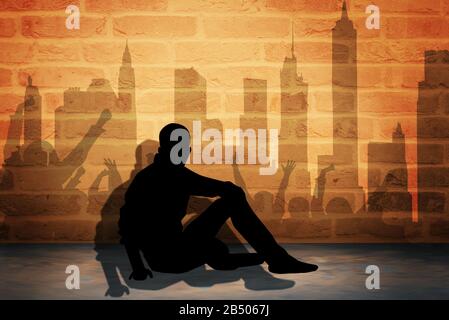 Mann sitzende Silhouette vor der orangefarbenen Wand, Stadt und Schatten Stockfoto