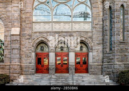 Rote Türen führen zu einer schönen Kirche in der Innenstadt von Atlanta, Georgia. Stockfoto