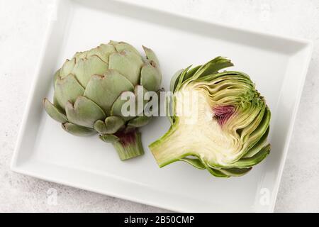 Grün geschnittene Artischocke in weißer Platte Stockfoto
