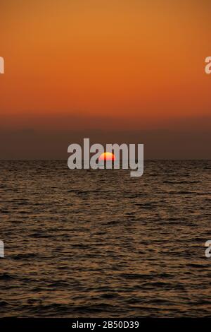 Schöner sonniger Sonnenuntergang am Meer. Verschiedene Farben und Farbtöne der aufgehenden Sonne. Stockfoto
