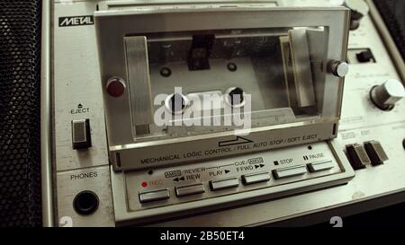 Der alte Kassettenspieler fügt eine Kassette in die Boombox ein. Retro-Kassettenspieler-Konzept. Stockfoto