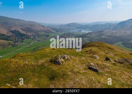 Grasmere Dorf und See, Fairfield Horseshoe und Loughrigg fielen im Hintergrund, vom Gipfel von Helm Crag, Grasmere, Lake District, Großbritannien aus gesehen Stockfoto