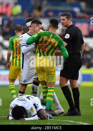 Schiedsrichter Robert Jones sieht so aus, als sich Swansea City Matt Grimes und West Bromwich Albions Hal Robson-Kanu beim Sky Bet Championship Match zwischen Swansea City und West Bromwich Albion im Liberty Stadium, Swansea, gegenseitig drücken. Stockfoto